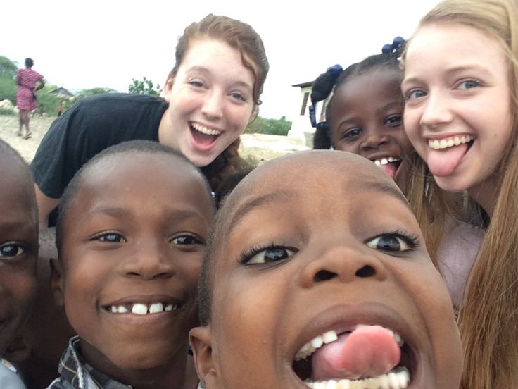 a group of young children standing next to each other with their mouths open and smiling