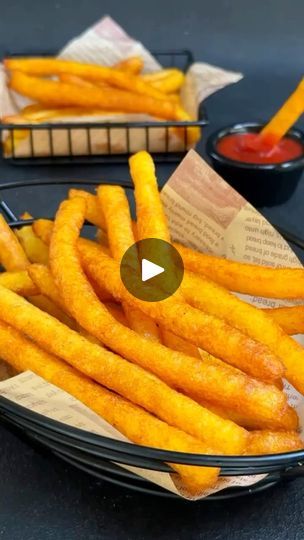 french fries with ketchup on the side in a black bowl next to some napkins