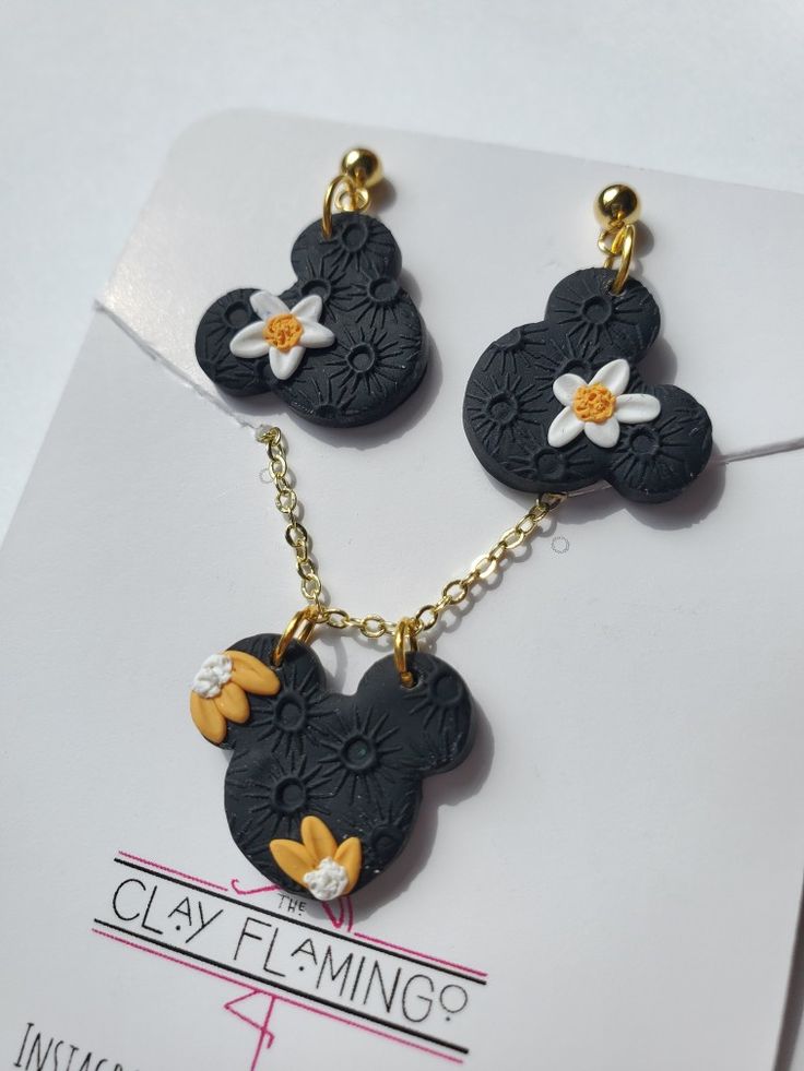 three mickey mouse charms on a card with the word clay flamingo written below them