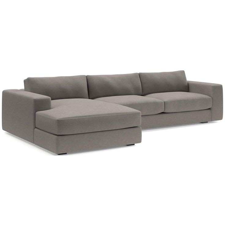 a gray sectional couch sitting on top of a white floor