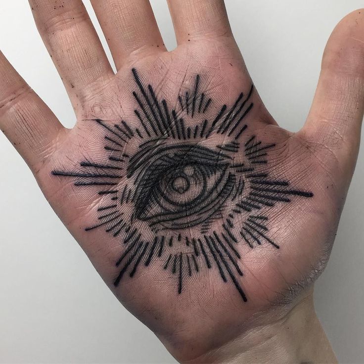 a hand with an all seeing eye tattoo on it