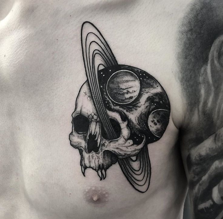 a man's chest with an image of planets and a skull in the middle