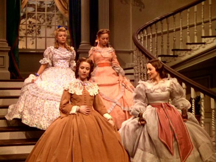 several women in dresses are standing on the stairs