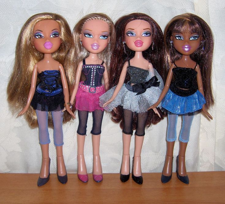 four dolls standing next to each other on a table