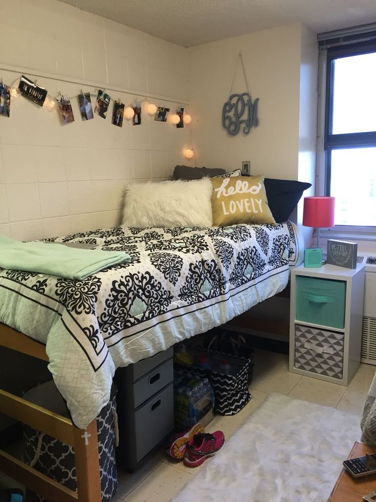 a bed room with a neatly made bed and lots of clutter on the floor