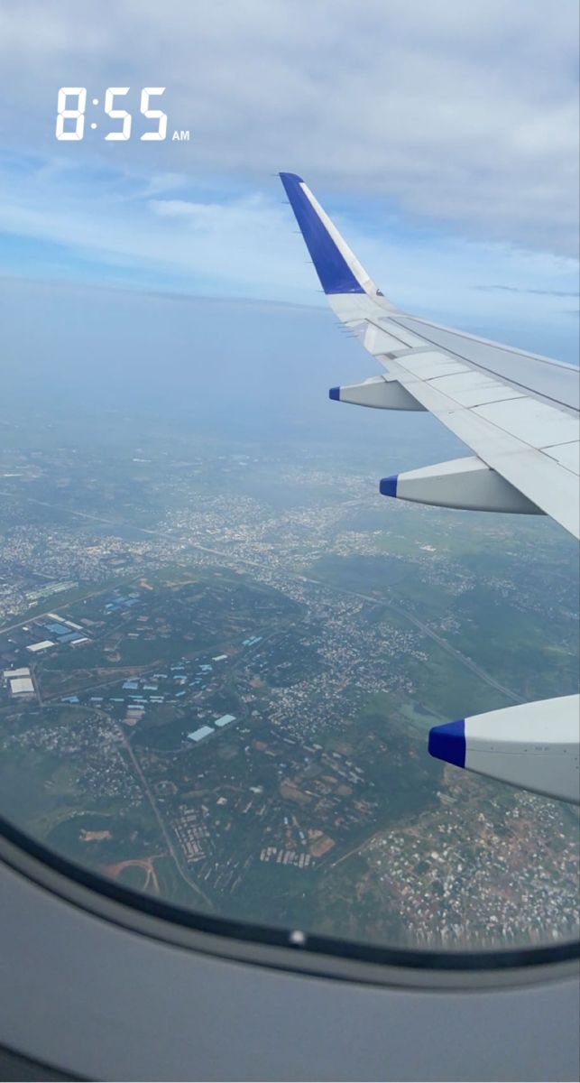 the wing of an airplane flying over a city