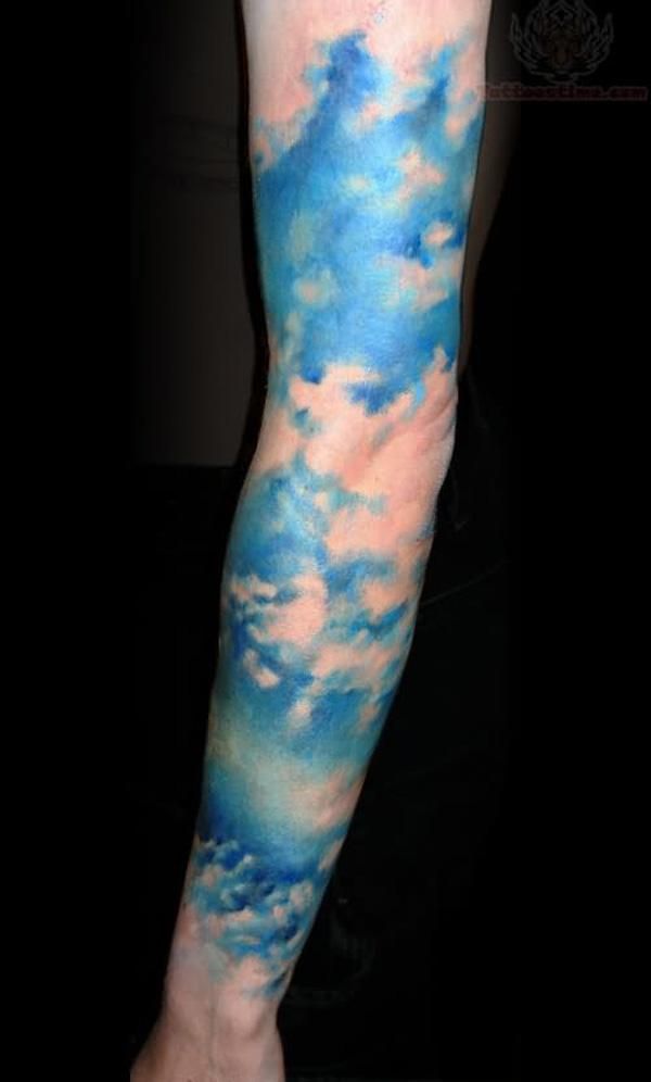 a man's arm with clouds and blue sky tattoos on his left arm,