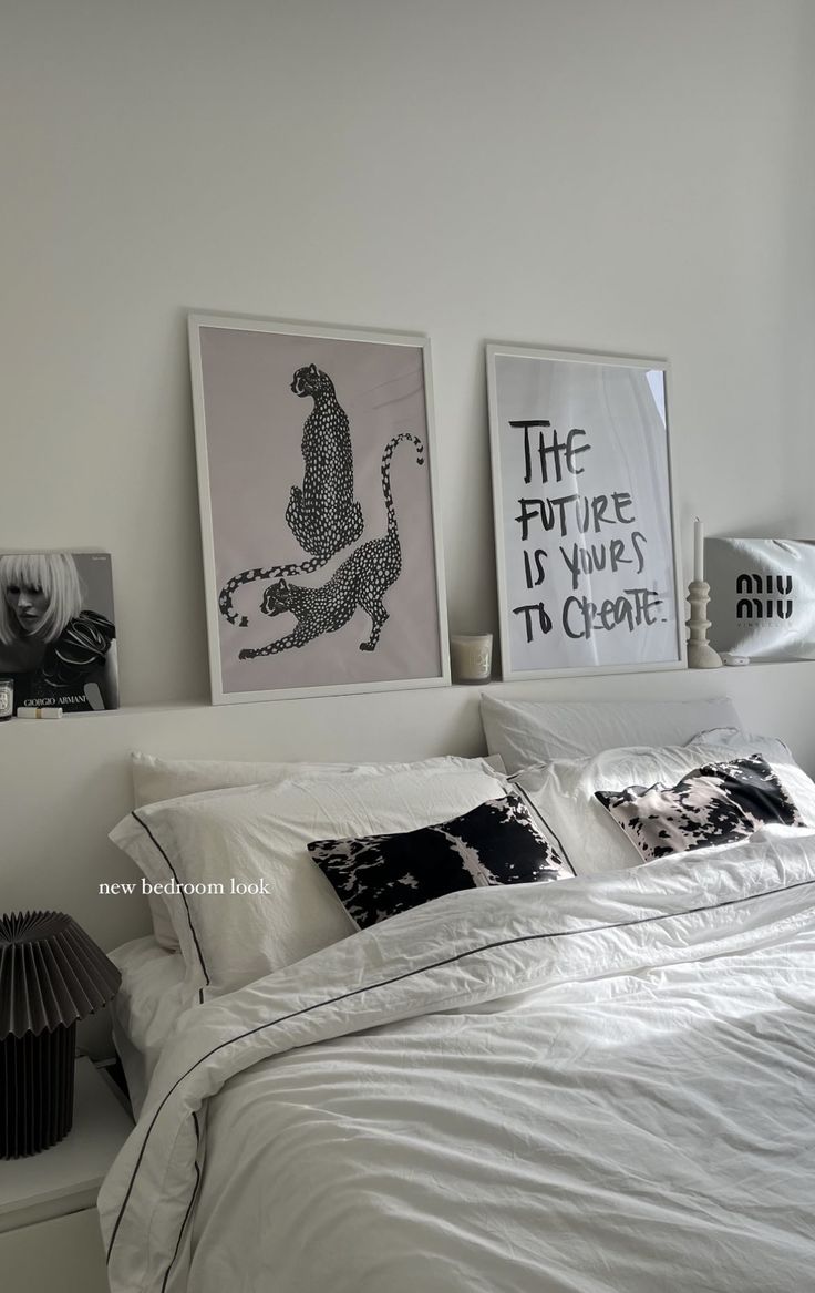 a bedroom with white walls and pictures on the wall