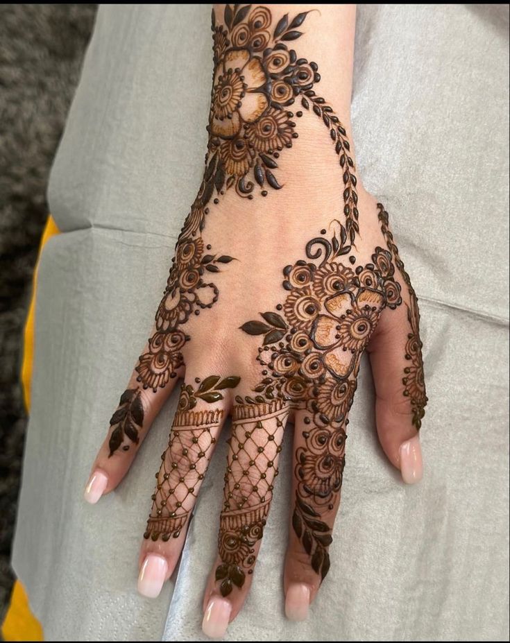 a woman's hand with henna tattoos on it