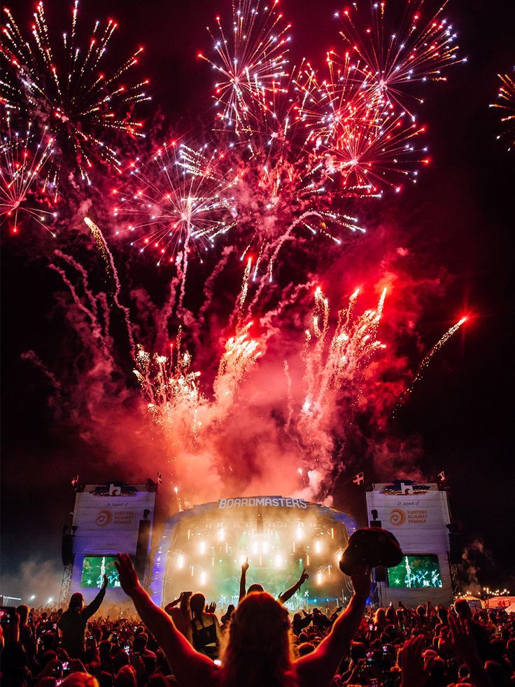 fireworks are lit up in the night sky at a concert