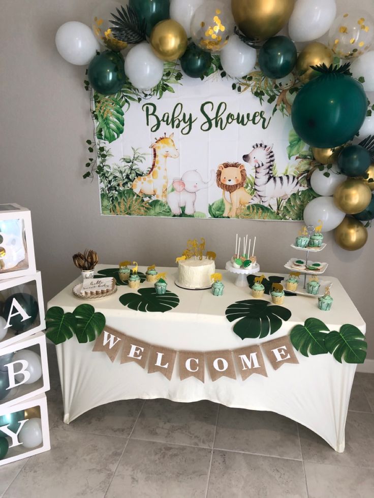 a baby shower is set up with balloons and jungle themed decorations, including a welcome sign