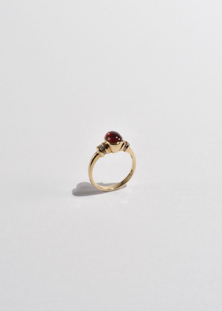 Beautiful vintage gold ring with a polished ruby cabochon and diamond detail. Stamped 10k. Material: 10k gold, ruby, diamond. We recommend storing in a dry place and periodic polishing with a cloth.