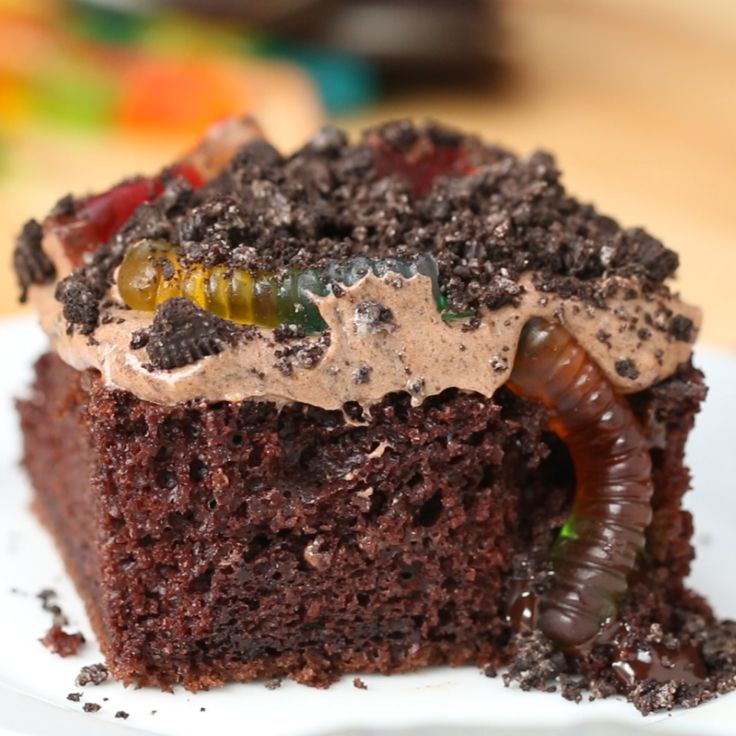 a close up of a piece of cake on a plate with worms crawling around it