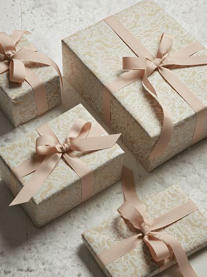 four gift boxes with pink bows on them