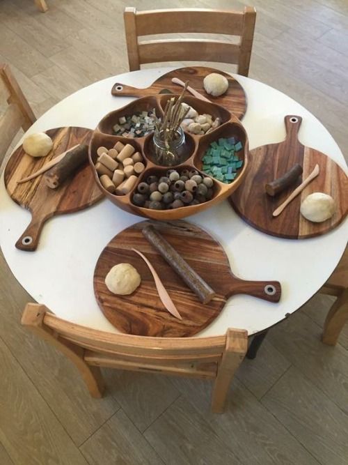 a wooden table topped with cutting boards and bowls filled with rocks on top of it