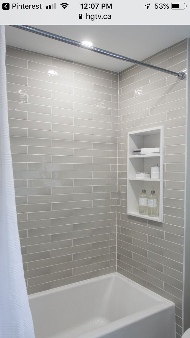 a white bath tub sitting under a bathroom window