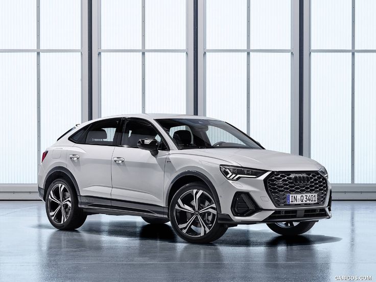 the new audi q3 suv is parked in front of large windows and glass walls