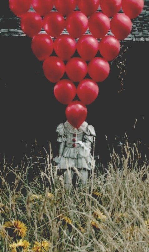 a bunch of red balloons floating in the air over a person's head and body