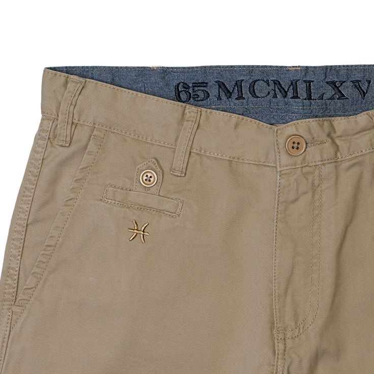 Get comfortable and noticed in our signature men's chino short. Classic straight fit with sharp detailing. Khaki color. Our khaki chino short is available in waist sizes 30/32/33/34/36/38. Refer to our Size Guide. Imported. The perfect fitting shorts to keep you cool at the office or on your day off. #65mcmlxvChinoShort Features - Contrast chambray inside waistband with logo embroidery - Logo embroidery below front coin pocket - Flat front - Zip fly closure; belt loops - Rear welt pockets with b Menswear Details, Khaki Shorts Men, Trousers Details, Mens Shorts Summer, Men Trousers, Mens Chinos, Mens Khakis, Khaki Color, Chino Pants