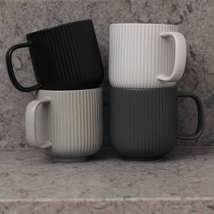 three coffee mugs stacked on top of each other in front of a marble wall