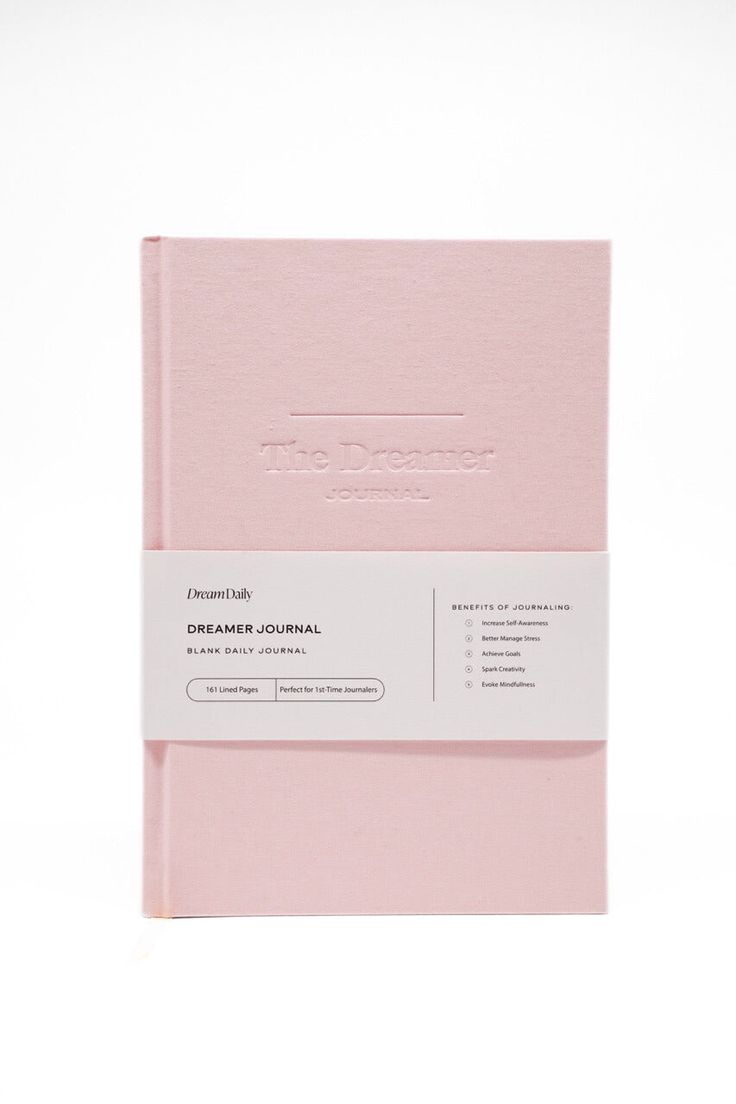 a pink notebook sitting on top of a white table