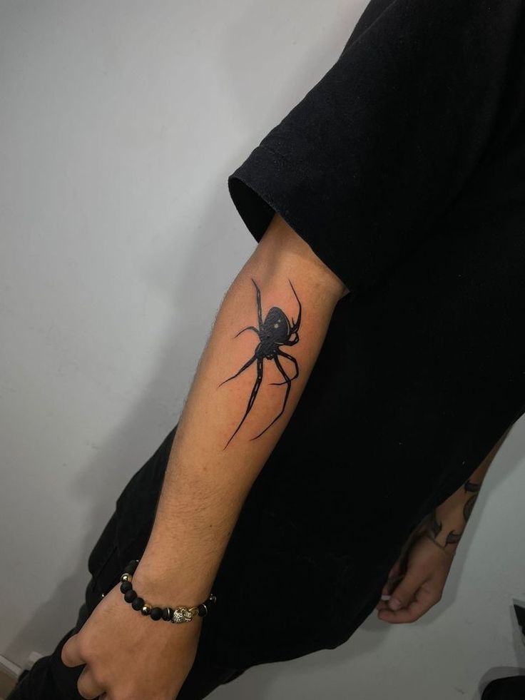 a man with a spider tattoo on his arm