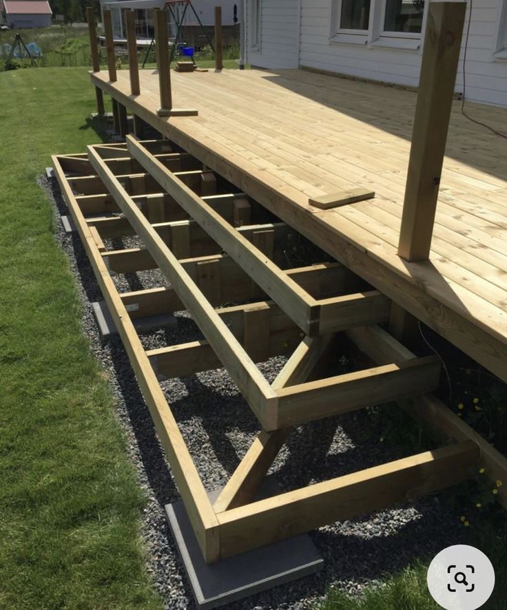 a wooden deck in front of a white house