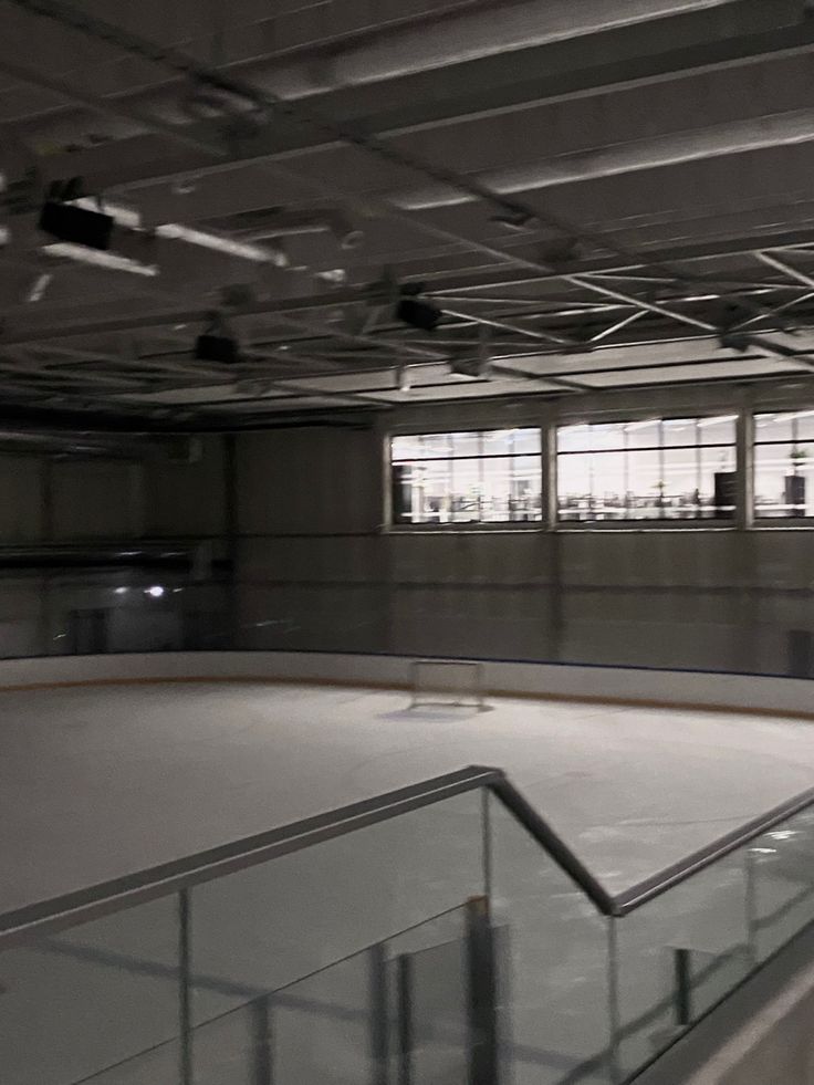 an empty skating rink with railings and windows