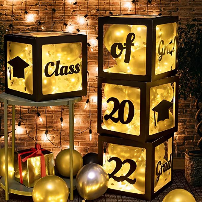 lighted cubes with numbers and graduation caps on them in front of a brick wall