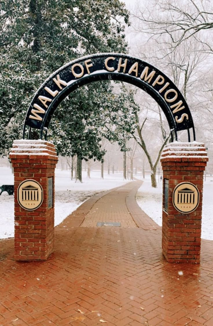 a brick walkway with two archways and a sign that says walk of champions on it