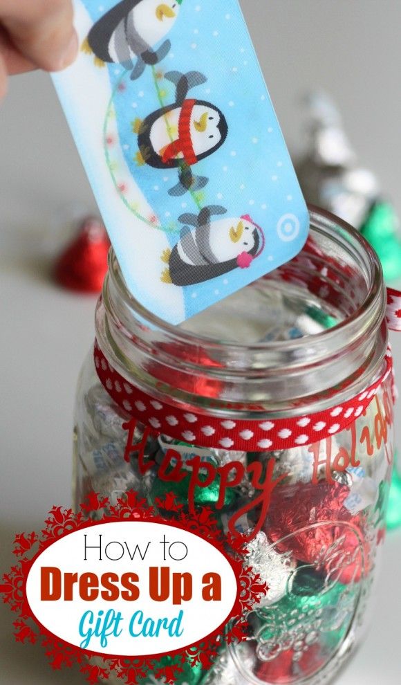 a person holding a penguin tag in a jar filled with christmas candies