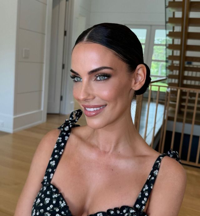 a woman in a black and white dress smiling at the camera