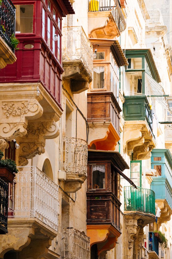 several balconies on the side of buildings in an alleyway with balconyes and balconies