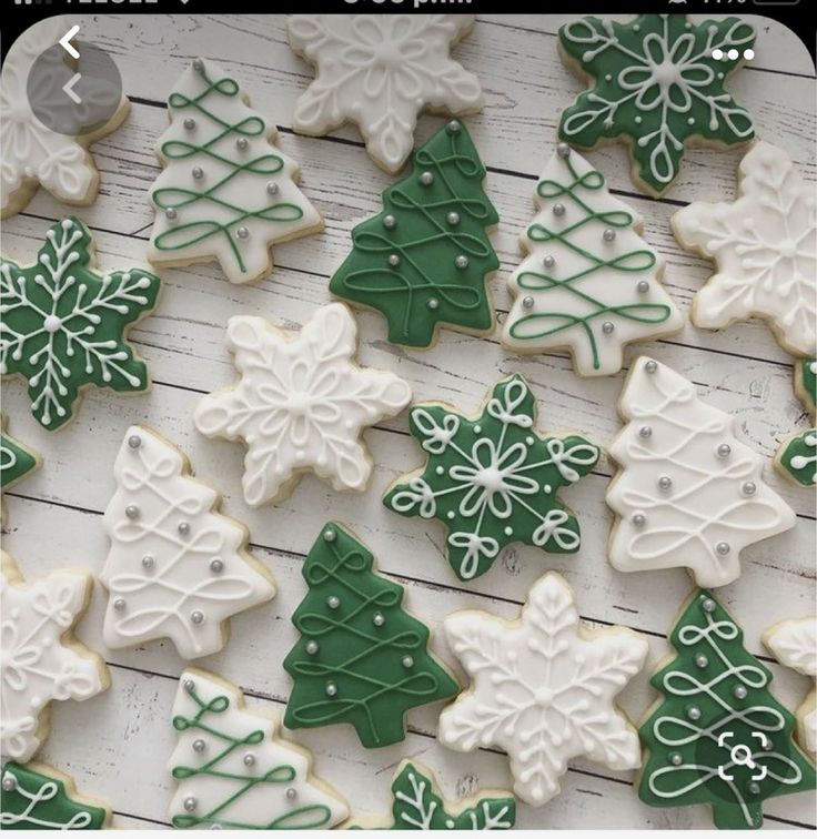 christmas cookies decorated with green and white icing are on a table next to each other