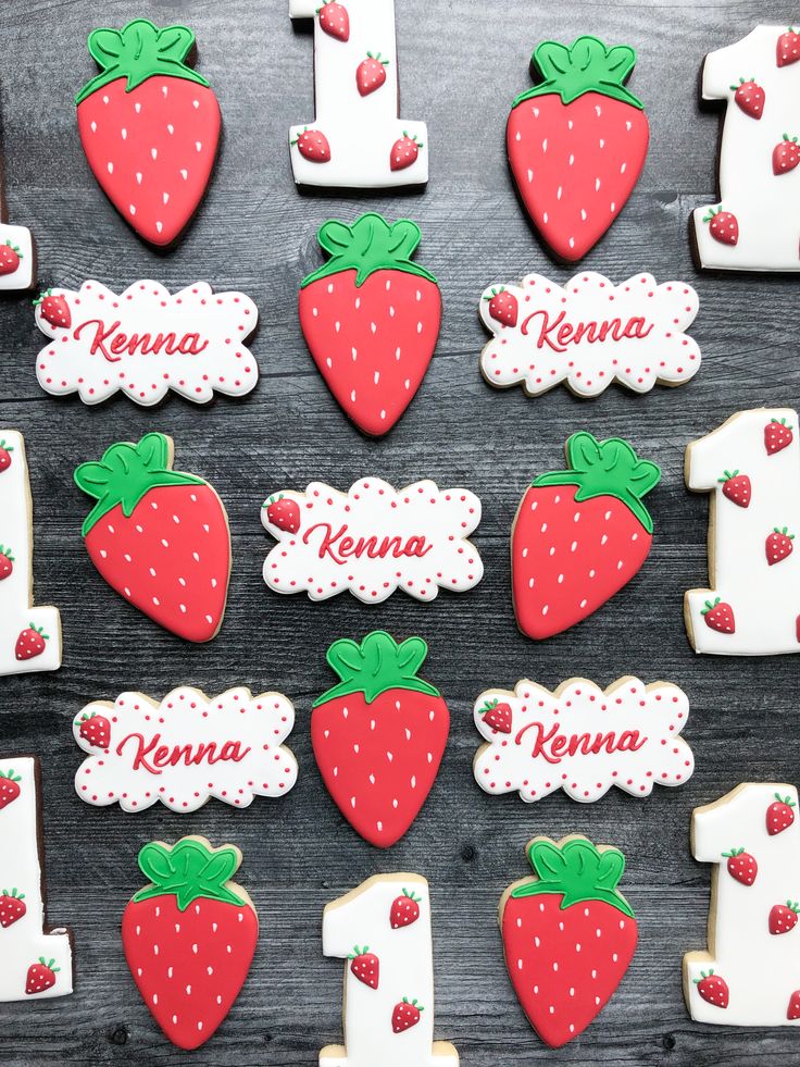 decorated cookies are arranged in the shape of letters and numbers with strawberries on them