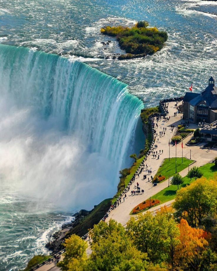 an aerial view of the niagara falls and surrounding buildings with people walking on the walkway