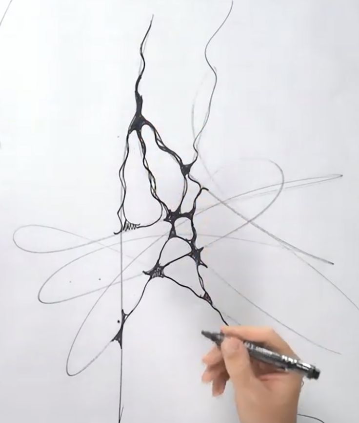 someone is drawing something with black ink on white paper