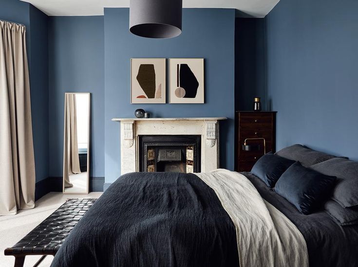 a bedroom with blue walls and black bedding