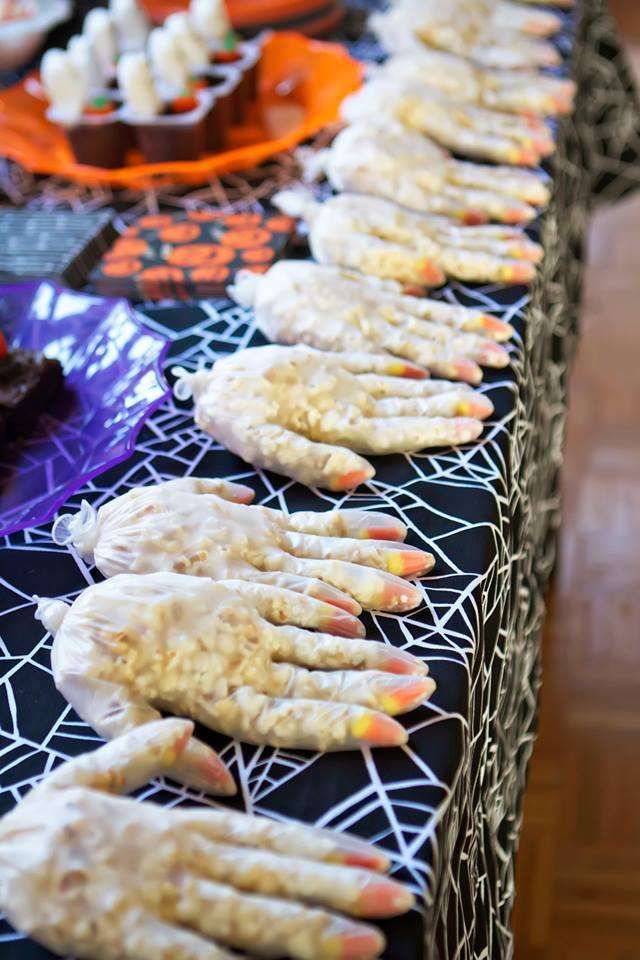 halloween treats lined up on a table with spider webs and sprinkles