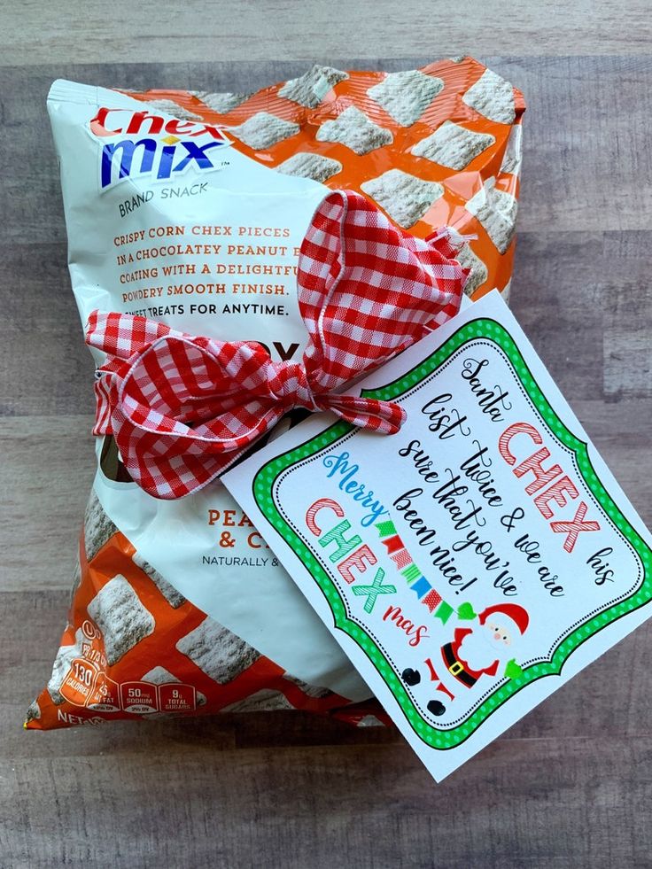 an orange and white bag with a red bow on it sitting on top of a wooden floor