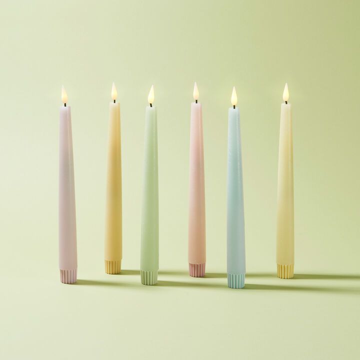 five different colored candles lined up next to each other