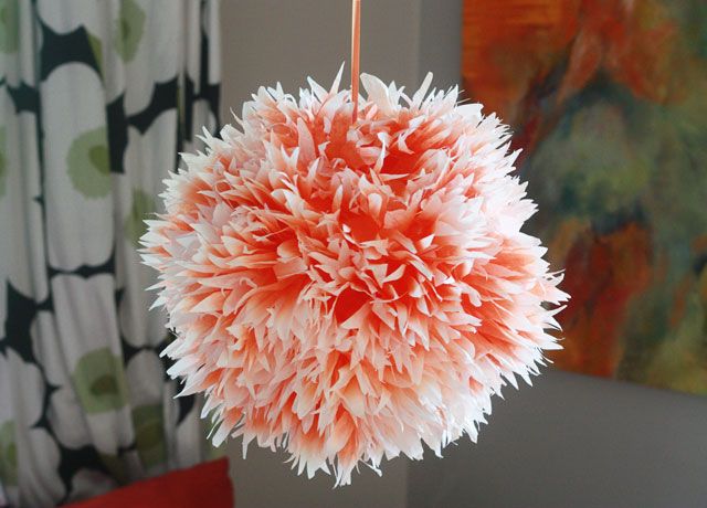 an orange and white pom - pom ball hanging from a hook on a web page