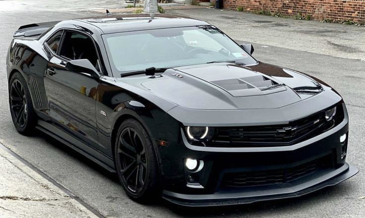 a black chevrolet camaro is parked on the street