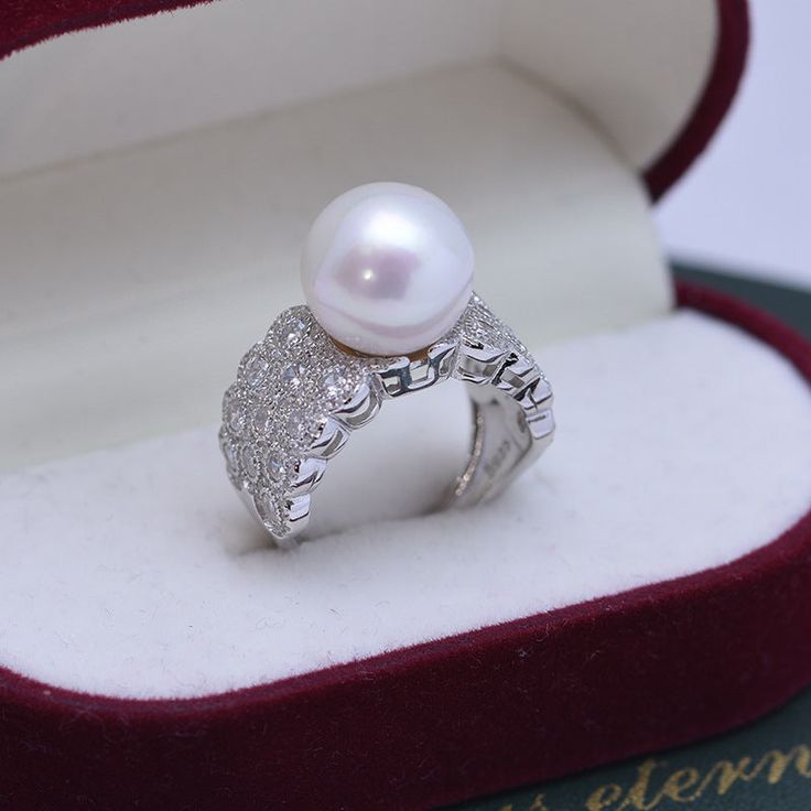 Looking for a timeless piece of pearl jewelry to add to your collection? House of Pearls’ 12-13mm Freshwater Pearl & Large Full CZ Wide Diamond Ring is the perfect classic addition. This ring offers a large 12-13mm freshwater pearl alongside a large full CZ diamond, making it wearable luxury. Celebrate your special moments by wearing this beautiful pearl & diamond ring. White 12-13mm Freshwater Pearl Ring This popular ring design features AAAA quality, round freshwater pearls measuring 12-13mm. Luxury Diamond Rings With Pearl Drop, Luxury White Rings With Pearl Drop, Luxury Akoya Pearl Ring With Pearl Drop, Luxury Pearl Drop Ring For Formal Occasions, Luxury Round Pearl Drop Ring, Luxury Round Ring With Pearl Drop, Luxury Akoya Pearl Ring For Formal Occasions, Luxury Diamond White Pearl Ring For Anniversary, Luxury Diamond White Akoya Pearl Ring