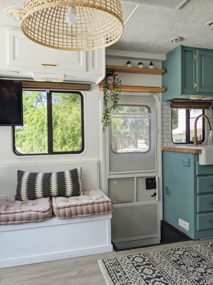 a living area with couches, cabinets and windows