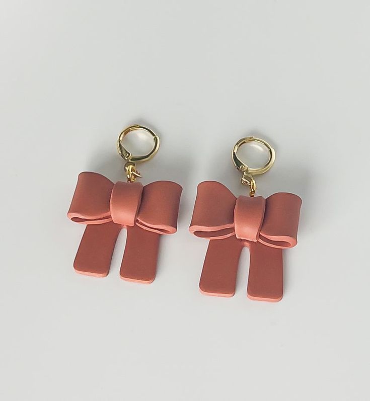 Handmade polymer clay bows in the color terracotta with a gold plated huggie hoop Trendy Handmade Rose Gold Jewelry, Elegant Resin Drop Earrings, Handmade Trendy Rose Gold Earrings, Chic Adjustable Jewelry With Bow Detail, Chic Adjustable Jewelry With Bow, Elegant Resin Earrings As Gift, Trendy Brown Jewelry For Gift, Chic Small Hoop Pink Jewelry, Chic Small Pink Hoop Earrings