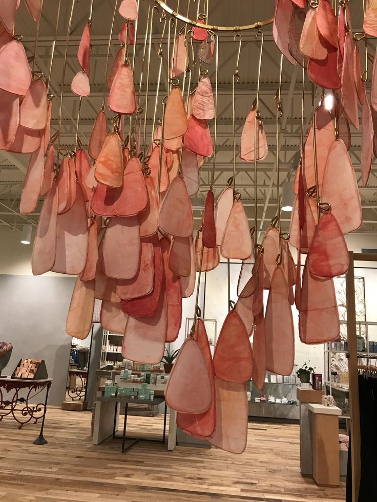 several pieces of meat hanging from the ceiling in a room with wooden floors and tables