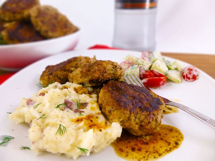 a white plate topped with meat patties and mashed potatoes