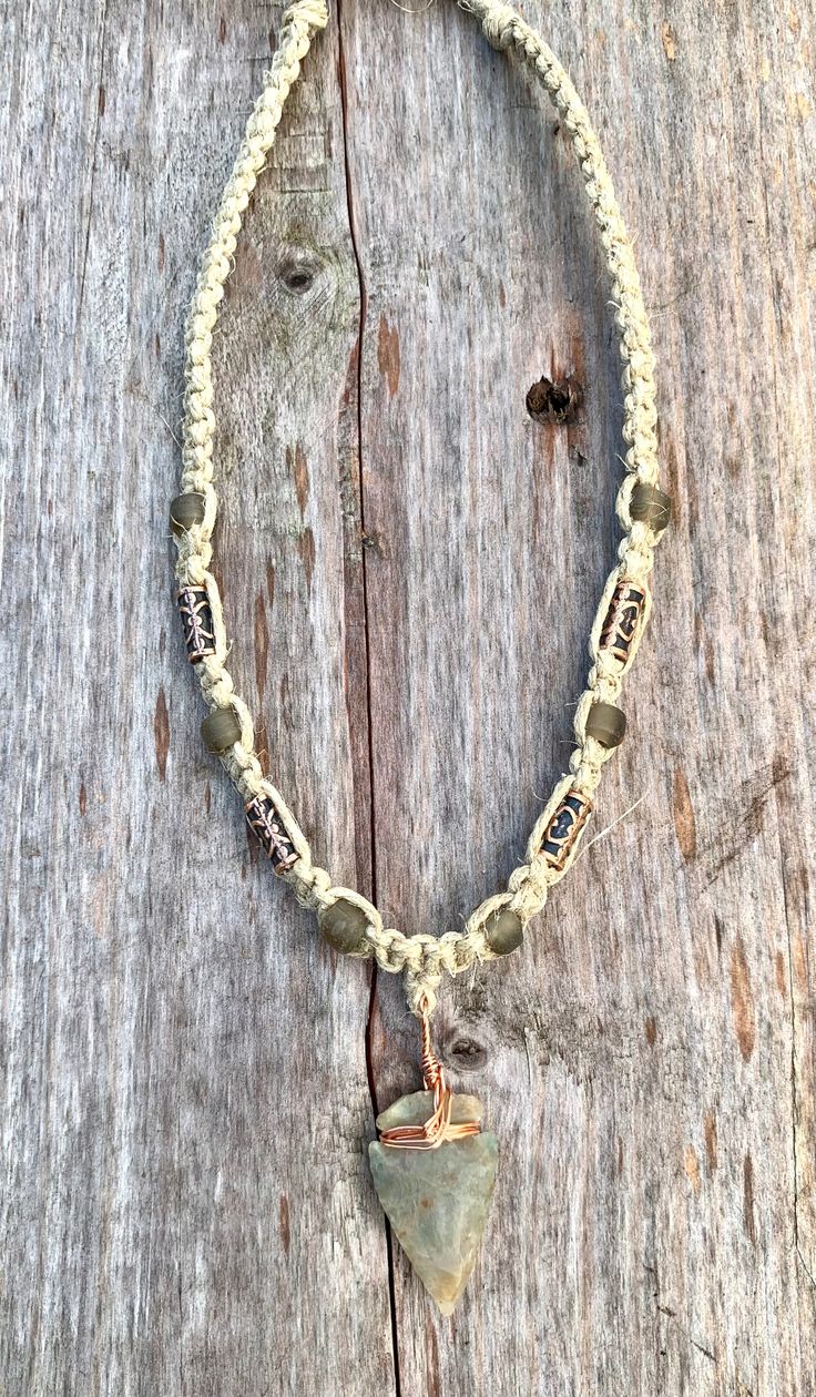 This handcrafted hemp choker features a unique arrowhead pendant made from flint stone, wrapped in copper wire. The pendants vary slightly in size, color, and texture, ensuring every piece is one-of-a-kind. Customizable lengths from 14 to 20 inches make this an adaptable accessory for any style. Ideal for lovers of primitive or tribal-inspired jewelry, this necklace showcases earthy tones and natural craftsmanship, perfect for men or anyone embracing bohemian aesthetics. Proudly made in the USA, Bohemian Necklace With Sliding Knot On Waxed Cord, Hippie Jewelry With Sliding Knot In Waxed Cord, Hippie Jewelry With Sliding Knot On Waxed Cord, Adjustable Waxed Cord Hippie Necklace, Rustic Adjustable Necklace With Waxed Cord, Adjustable Rustic Necklace With Waxed Cord, Adjustable Wire Wrapped Arrowhead Necklace, Adjustable Cord Necklace For Festivals, Hand Wrapped Adjustable Necklace With Waxed Cord