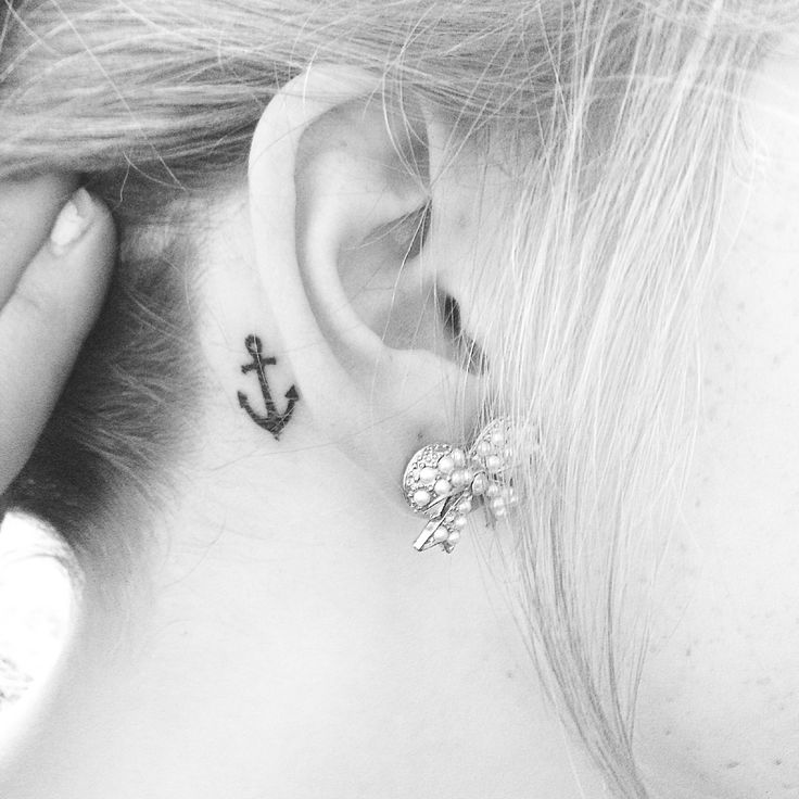 a woman with a small anchor tattoo on her left ear